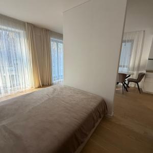 a bedroom with a bed in a room with windows at Nerija in Juodkrantė