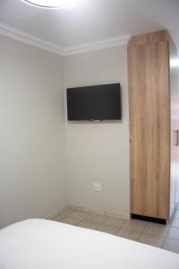 a room with a flat screen tv on a wall at Phela Guesthouse in Edenvale