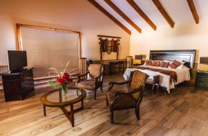 a bedroom with a bed and a table and chairs at Hotel Boutique Refugio El Molle in El Molle