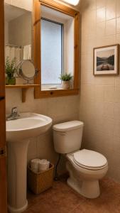 ein Badezimmer mit Toilette, Waschbecken und Spiegel in der Unterkunft L'Ours Bleu in Lac-Saguay