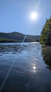ein Gewässer mit der Sonne im Hintergrund in der Unterkunft L'Ours Bleu in Lac-Saguay