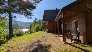 ein Haus auf einem Hügel mit Blick auf einen See in der Unterkunft L'Ours Bleu in Lac-Saguay