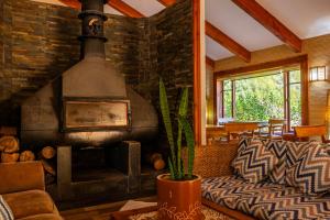 a living room with a large brick fireplace at Hotel Boutique Refugio El Molle in El Molle