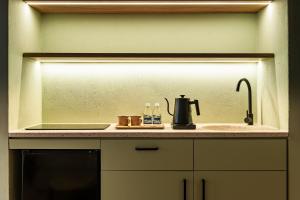a kitchen counter with a sink and a coffee maker at Obra Hotels in Medellín