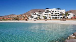 a large white building on the beach next to the water at Vista Cortes 2BR 2BA Condo - Walk to the Malecon! in La Paz
