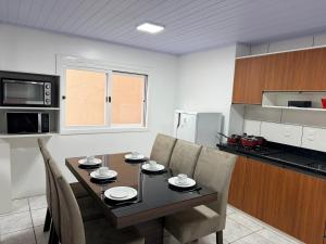 a kitchen with a dining room table and chairs at Aptos Weber - Piratini in Gramado