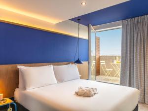 a bedroom with a white bed with a blue wall at greet hotel Marseille Parc Chanot Velodrome by Accor in Marseille +72 photos