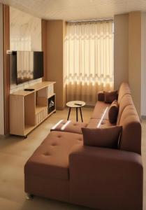 a living room with a couch and a tv at APART SExTA ESTACIÓN in Juliaca