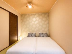 a bedroom with a bed with two pillows on it at Vieuno Hida Takayama 5-Min Walk to Station, Cozy Local Stay in Takayama