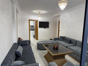 a living room with a couch and a table at Alhoceima - vue sur la mer- Green village2 in Al Hoceïma