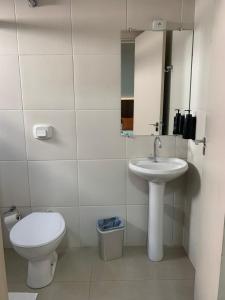 a white bathroom with a toilet and a sink at Hotel Iaguara in Coxim +28 photos