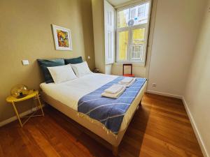 a bedroom with a bed with two towels on it at Lux Old Town in Lisbon +20 photos