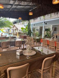 ein Außenrestaurant mit einem Tisch und Stühlen und Tischen und Stühlen in der Unterkunft Samui Zenity in Mae Nam