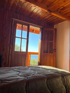 a bedroom with a bed and a large window at Olly Patagonia Suites in San Carlos de Bariloche