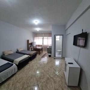 a hotel room with two beds and a television at Hotel Parque Mamed in Diadema