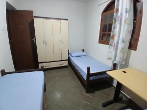 a room with a bed and a desk and a table at Pousada Familiar 31 in Campos dos Goytacazes