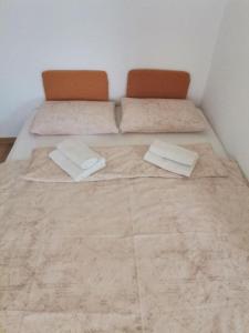 a bed with two pillows in a room at Ela Apartments - 1 in Kranjska Gora