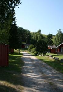 a dirt road with houses and trees on the side at Degeberga Stugby in Degeberga