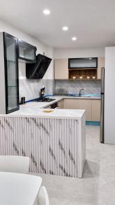 a kitchen with a white counter and a refrigerator at Appart Ilyani in El Kseur