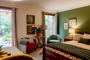 a bedroom with green walls and a bed and a chair at Green Gables Bed and Breakfast in Cygnet