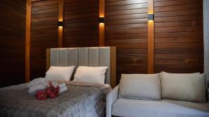 a bedroom with a bed and a couch with flowers on it at Chalés Florenzza in Santa Teresa
