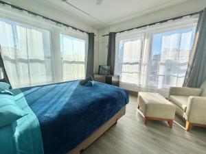 a bedroom with a bed and a chair and windows at California Dreams Hostel - Downtown in San Diego +65 photos