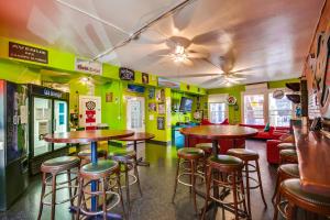 a bar with tables and stools in a room at California Dreams Hostel - Downtown in San Diego