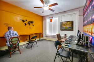 a man sitting in a chair in a room at California Dreams Hostel - Downtown in San Diego