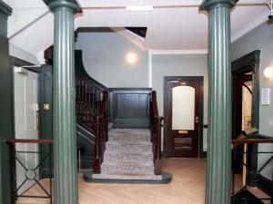 a hallway with columns and a staircase in a house at Mercure Thurrock Stifford Hall in Grays Thurrock