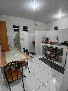 a kitchen with a table and chairs in a room at Pousada Familiar 31 in Campos dos Goytacazes