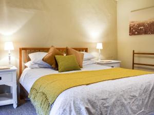 a bedroom with a large bed with two night stands at Barters Cottage in Chideock +8 photos