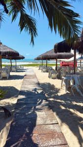 a beach with some straw umbrellas and chairs at Season Ilhéus in Ilhéus