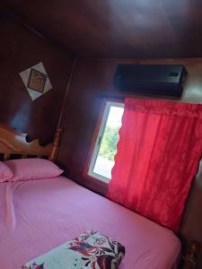 a bedroom with two beds and a window with avertisement at Casa HerShei in Orange Walk