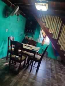 a table and chairs in a room with a green wall at Casa HerShei in Orange Walk
