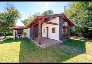 a small white house with a wooden roof at Cabañas Siddharta in Los Reartes