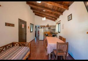 a dining room with a table and chairs and a kitchen at Cabañas Siddharta in Los Reartes