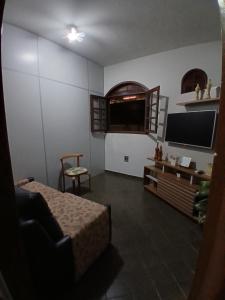 a bedroom with a bed and a tv and a chair at Pousada Familiar 31 in Campos dos Goytacazes