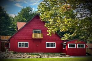 a red barn with a balcony on top of it at Sweet Forest Breeze, A Cook Forest Inn in Marienville