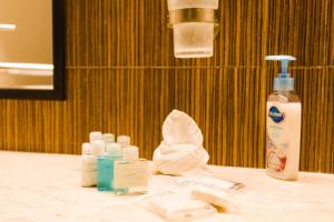 a bathroom counter with bottles of moisturizers and a towel at Ocean Front Corto Maltes 104 in Downtown in Playa del Carmen
