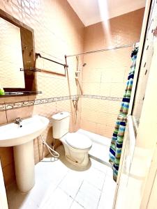 a bathroom with a toilet and a sink at Emerald Inn Karawaci in Dungus