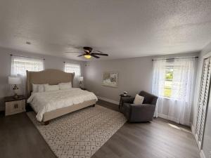 a bedroom with a bed with a ceiling fan and a chair at my place to be in Port Charlotte