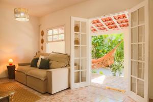 a living room with a couch and an open door at Casa Laguna - Geribá in Búzios