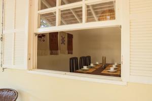 a room with a window with a table and chairs at Casa Laguna - Geribá in Búzios