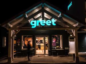 a person walking in front of a store at night at greet Hotel Belleville en Beaujolais A6 in Belleville-sur-Saône