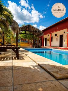 a swimming pool with a picnic table next to a building at Maruá Pousada da Lagoa in Jijoca de Jericoacoara