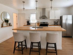 a kitchen with a counter and three bar stools at Homestead Bungalow in Dayton