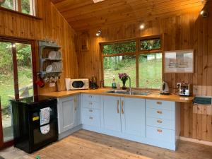 a kitchen with white cabinets and a sink in a cabin at Portlea Cabin in Oban