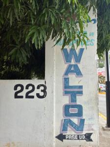 a sign on a wall next to a street at Casa Walton in Acapulco