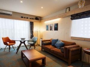 a living room with a couch and a table at Yomitan Condhotel ND in Yomitan