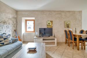 a living room with a couch and a table with a tv at Historic Old Town Kotor in Kotor